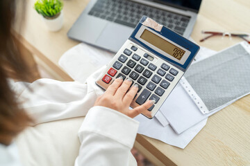 Human use calculator and calculate bills and paying bill, credit card, tax and vat, payment, concept of money management and business report with financial documents, financial accounting concept