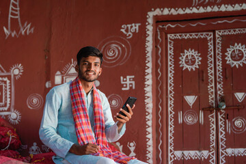 young indian farmer using smartphone at home