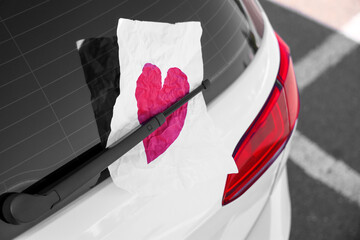 Sheet of paper with heart behind rear window wiper, closeup. I love my car concept