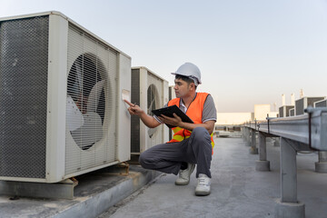 Asian maintenance engineer works on the roof of factory. contractor inspect compressor system and...