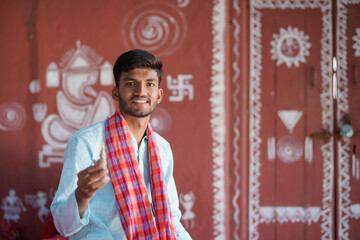 indian farmer holding Ginger and pointing