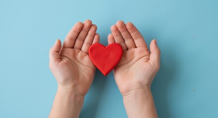 Fototapeta premium Hands cupping red heart shape turquoise background protection love care symbol. Person holding heart gesture charity support compassion. Love kindness concept banner horizontal