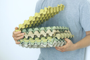Used egg trays for reuse. A man holding empty egg cartons, symbolizing sustainable food packaging and smart household consumption practices. Ideal for topics on eco-packaging and grocery habits