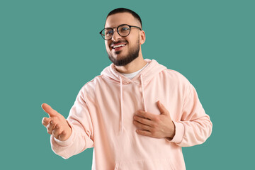 Thankful young man pressing hand to chest and smiling on green background
