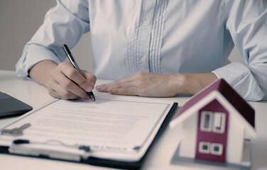 Businesswoman real estate agent signs documents and gives home insurance advice Create a home...