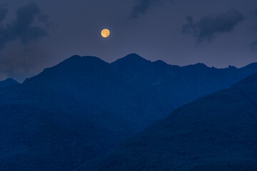 Twilight Over Mountain Peaks with the Moon