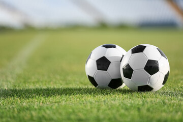 Soccer balls on green stadium grass, closeup