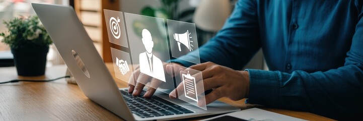 Person using a laptop with holographic business icons overlay.