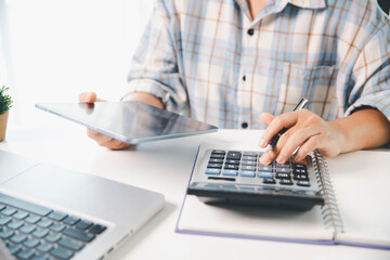 Accountant working on desk using calculator for calculate finance report in office. business...
