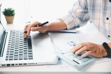Accountant working on desk using calculator for calculate finance report in office. business...