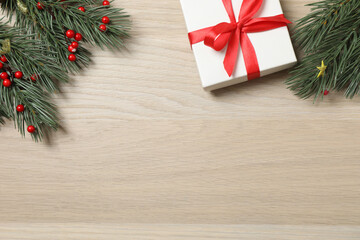 Christmas decorations and gifts on light wood background