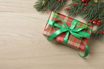 Christmas decorations and gifts on light wood background