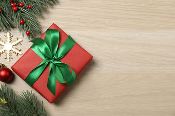 Christmas decorations and gifts on light wood background