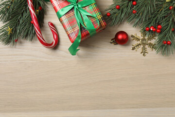 Christmas decorations and gifts on light wood background