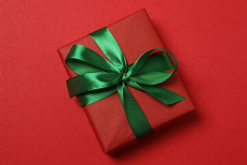 Top view of gift box trinket, fir branch, on red background, space for text