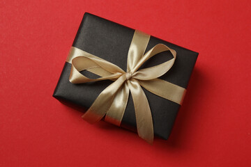 Top view of gift box trinket, fir branch, on red background, space for text