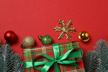 Top view of gift box trinket, fir branch, on red background, space for text