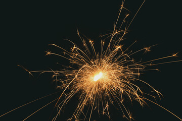 Burning sparks flying. Beautiful flames. Fiery orange glowing flying away particles on black...