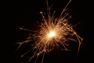 Burning sparks flying. Beautiful flames. Fiery orange glowing flying away particles on black...