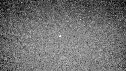 Obraz premium Grayscale Asphalt Texture with Speckled Surface and Subtle Light Spot