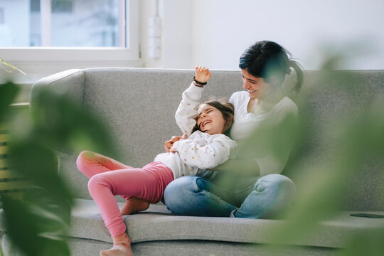 Mother and daughter enjoying quality time together on a sofa indoors