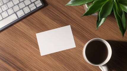 Blank business card on wooden desk beside a coffee cup and green plant with keyboard