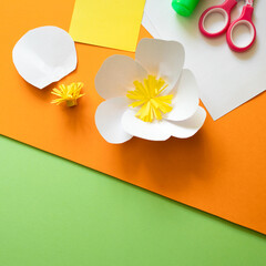 summer paper flowers on bright orange background . kids art craft diy gift