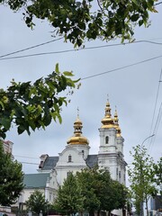Church in the city center, beautiful architecture of the old city, Cathedral of the Transfiguration of the Lord. Golden domes with crosses on the Orthodox church against the sky.