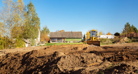 Yellow bulldozer at a construction site. Big wheel excavator leveling and clearing the land plot...