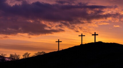 Dramatic sunset sky with vibrant orange and purple clouds over three crosses on hill.
