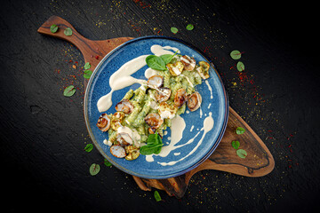 Italian pasta with zucchini, parmesan, spinach, and mussels on a dark background. Fresh and elegant seafood dish.