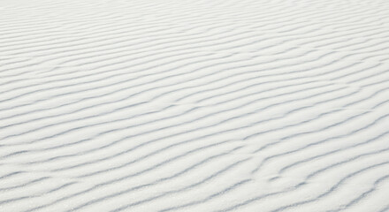 Obraz premium Close-up view of white sand dunes with subtle wave patterns.
