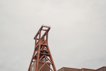 Side view of Zollverein Coal Mine Industrial Complex tower with overcast sky background in Essen,...