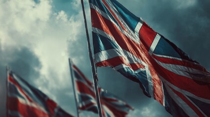 Multiple Union Jack Flags Flying Against Dark Cloudy Sky During Windy Weather.