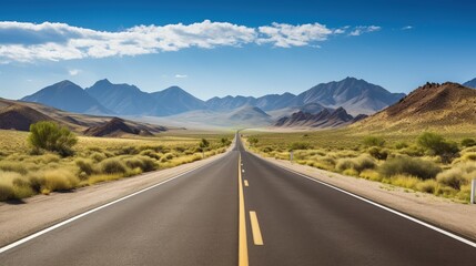A long empty highway stretches through a dry desert valley with mountains under a partly cloudy blue sky.