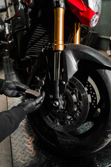 Front Brake Pad Replacement on Red Sport Motorcycle. Front brake pads are inspected and swapped out...