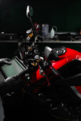 Motorcycle system diagnostic, scanning for faults across engine, electrical, and sensor modules to ensure reliability. Mechanic performing system diagnostics via tablet.