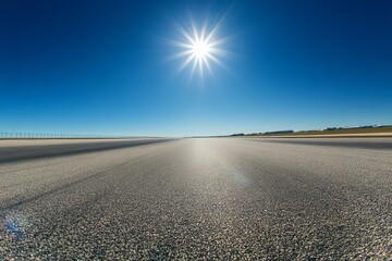 Empty runway under a bright sun.