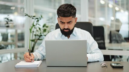 Professional businessman in a light shirt intently works on his laptop, taking notes in a modern, bright office. He is focused and determined, dedicated to his important business tasks. - Powered by Adobe