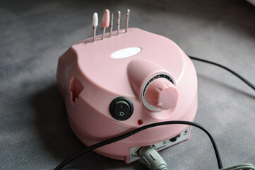 pink electric nail drill machine with attached handpiece and interchangeable bits. professional...
