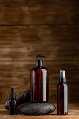 Elegant amber cosmetic bottles mockup on rustic wooden background, barber shop