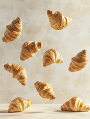 Freshly baked croissants floating on a warm beige background