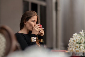 Woman Coffee Lifestyle: Woman drinking coffee in cafe during daytime for relaxation outdoors.