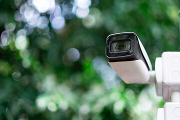 CCTV camera security surveillance device technology with green nature bokeh background.