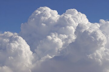 Fluffy white cumulus clouds against a clear blue sky