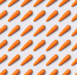 Young orange carrot on light gray background. Organic healthy vegetables, superfood, vitamins for human health. Creative food background, carrot pattern, agriculture. Top view flat lay