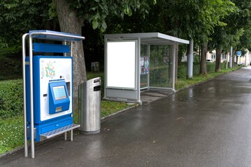 Poster at the bus stop with ticket machine.