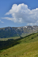Fototapeta premium Cumulus clouds over the Bucegi massif in early summer morning