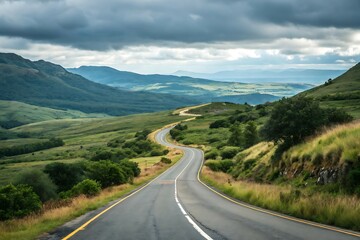 Fototapeta premium Winding Road Through a Serene Green Landscape Under a Cloudy Sky