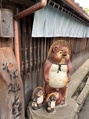 Tanuki Statue in Nara Japan - a traditional tanuki statue stands at the edge of a narrow alley in...